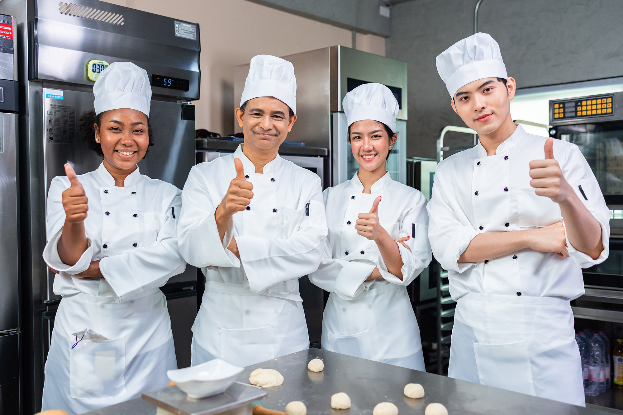 Four smiling bakers baking together in a bakery 01